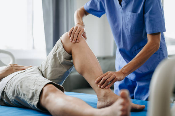 Close up of Physiotherapist working with patient on the bed in clinic